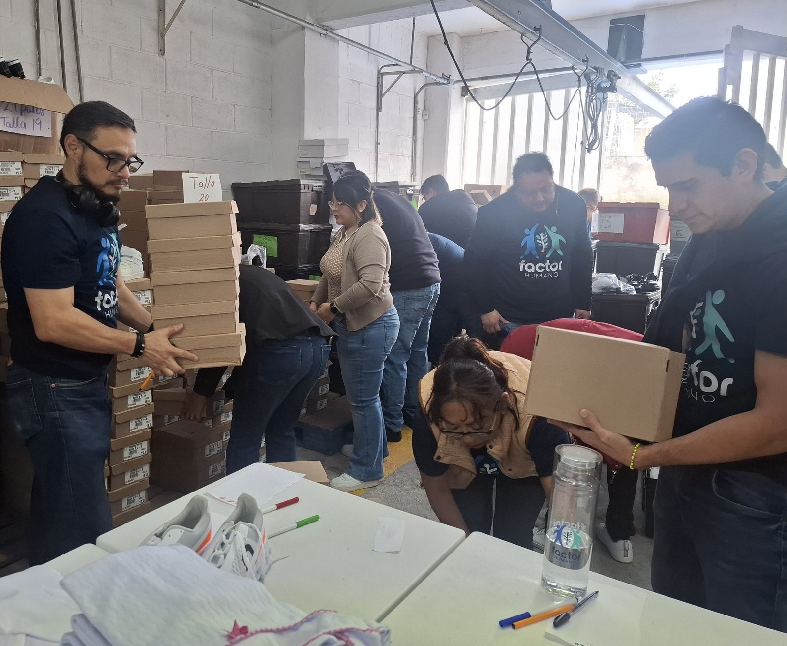 Voluntarios de Factor Exprés organizando donativos durante la campaña "Mochila completa"